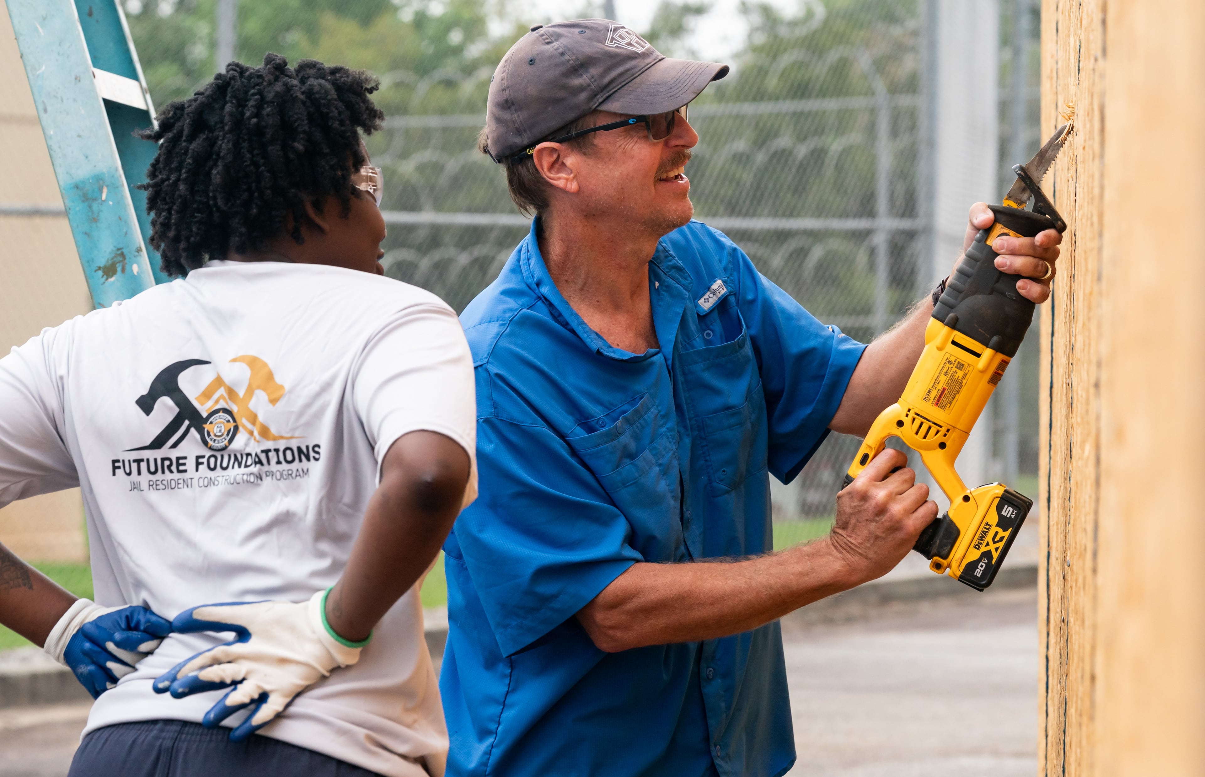 State Rep. Spencer Frye demonstrates using a saw for Zykeria Ellis, an inmate at the Athens-Clarke County Jail in Athens. Frye, also the executive director of the Athens area Habitat for Humanity, proposed the jail’s Future Foundations program, which teaches female inmates construction skills. (Seeger Gray/AJC 2024)