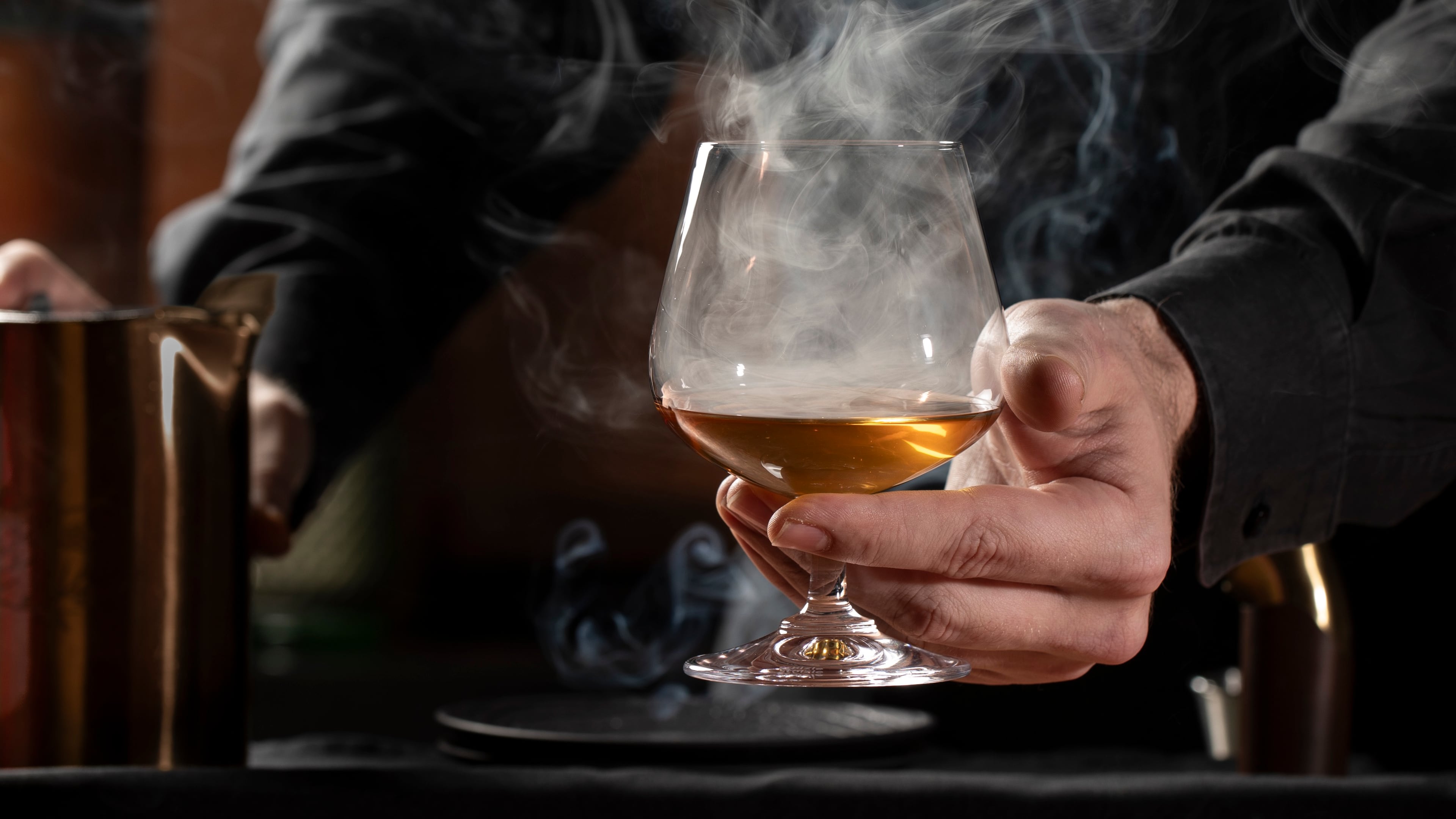 Mixologist Brendan Seery lights cinnamon and clove powder to make the smoke in the aptly named Kemuri cocktail at Himitsu. (Courtesy of Lara Kastne)