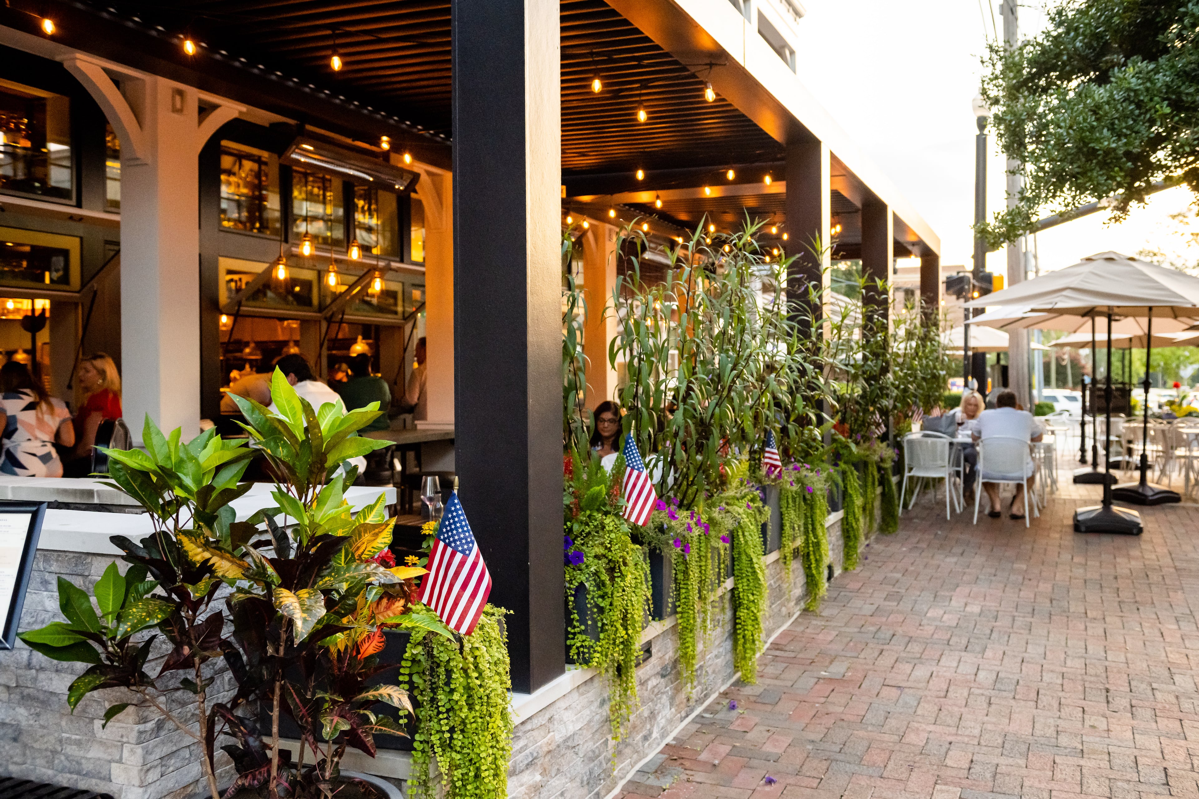 A covered patio — with bar and island counter seating, along with fire tables and heat lamps during chilly months — makes Fogón and Lions a lively outdoor gathering spot. (Courtesy of Fogón and Lions)