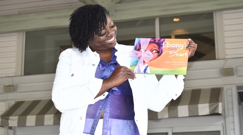 Dionne Monique holds her book "Ebony's Purple Scarf." Courtesy of Dionne Monique