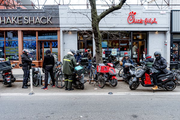 FILE - Delivery workers wait in front of restaurants for orders, Feb. 1, 2024, in New York. (AP Photo/Peter K. Afriyie, File)