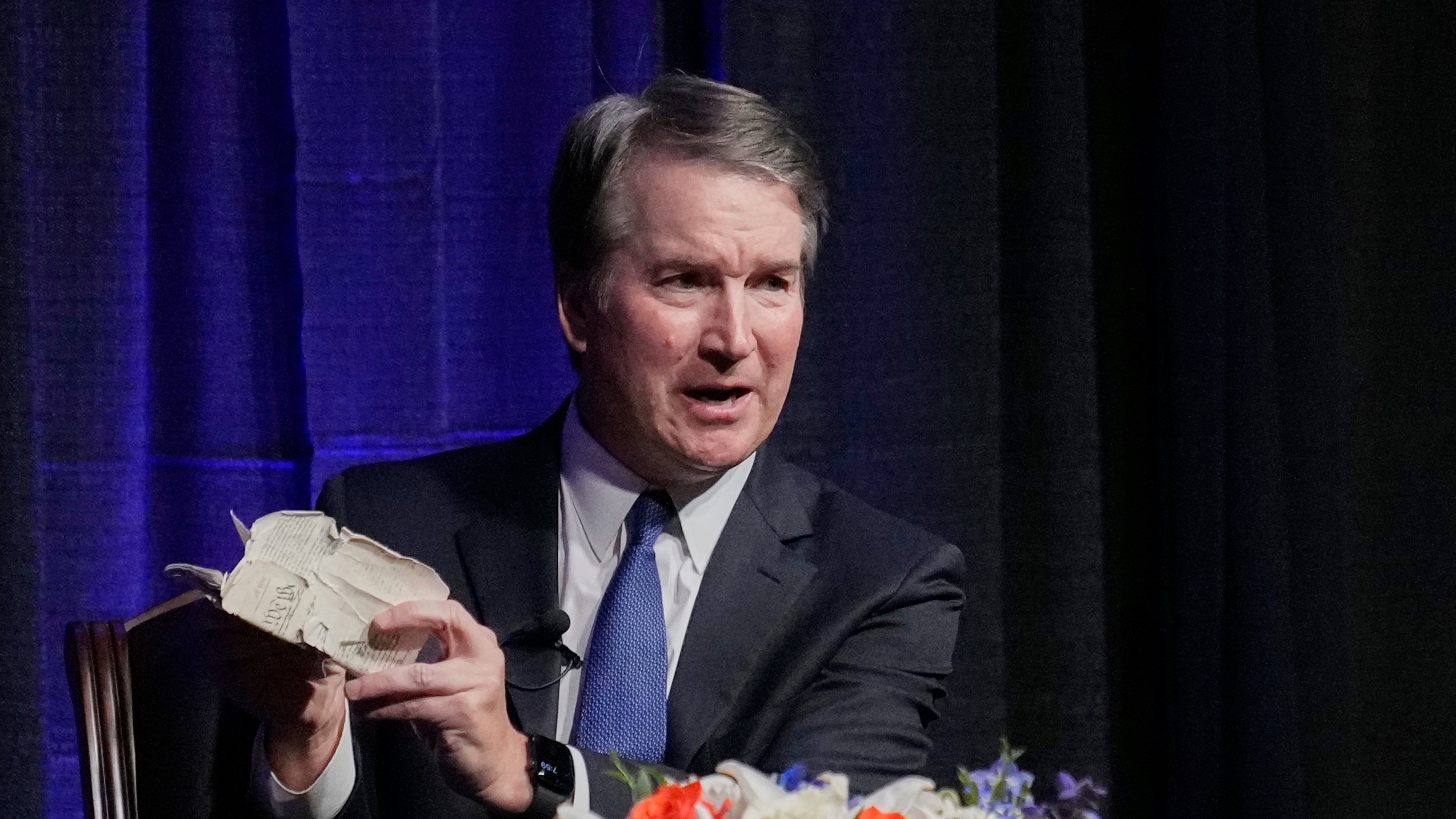Justice Brett Kavanaugh holds his personal pocket constitution as he speaks at The Ken Starr Lecture at McLennan Community College, Thursday, Sept. 11, 2025, in Waco, Texas. (AP Photo/Tony Gutierrez)