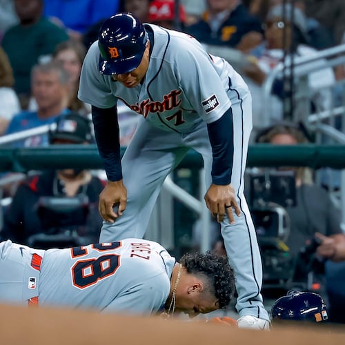 Detroit Tigers' Javier Baez (28) reacts after injuring his right leg running to first base on a ground ball against the Atlanta Braves, as Detroit Tigers first base coach Anthony Sanders (77) looks on during the fifth inning of a baseball game, Tuesday, April 28, 2026, in Atlanta. (AP Photo/Erik S. Lesser)