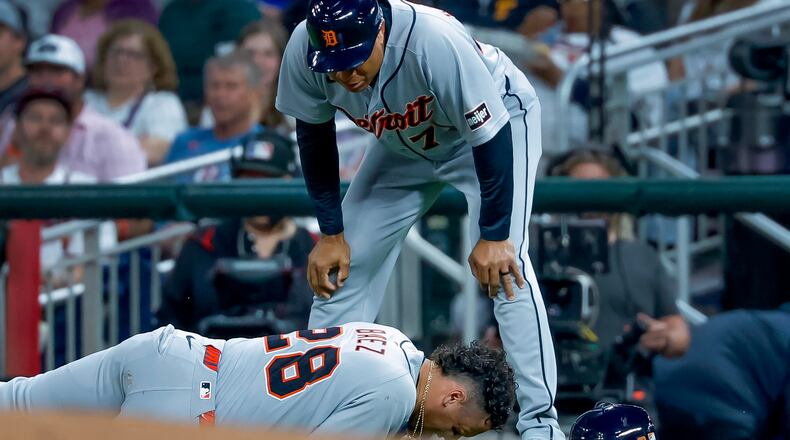 Detroit Tigers' Javier Baez (28) reacts after injuring his right leg running to first base on a ground ball against the Atlanta Braves, as Detroit Tigers first base coach Anthony Sanders (77) looks on during the fifth inning of a baseball game, Tuesday, April 28, 2026, in Atlanta. (AP Photo/Erik S. Lesser)