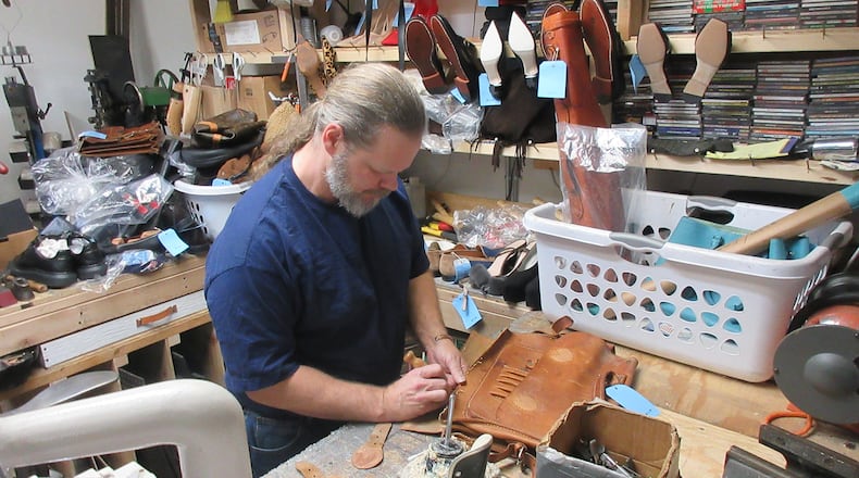Ryan Embry of Classic Shoes & Repairs works on a well-worn purse. Courtesy of Ryan Embry