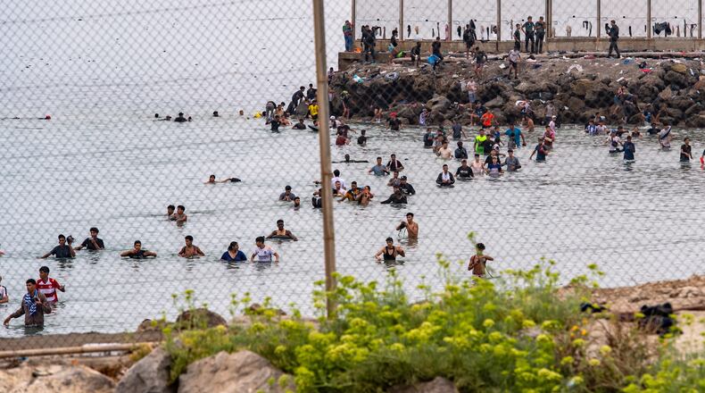 Migrants try to cross from Morocco into the Spanish enclave of Ceuta, Friday, July 31, 2026. (AP Photo/Antonio Sempere)