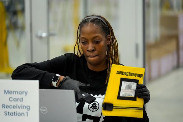 FILE - An election worker scans an envelope that holds a voting machine memory card at the Fulton County Election Hub and Operation Center, Tuesday, Nov. 5, 2024, in Atlanta. (AP Photo/John Bazemore, File)