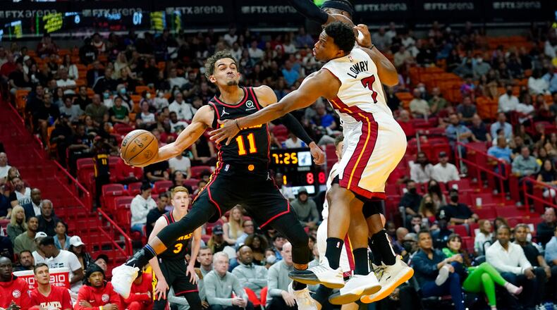 Atlanta Hawks guard Trae Young (11) passes the ball as Miami Heat guard Kyle Lowry (7) defends during the first half of an NBA basketball game Friday, April 8, 2022, in Miami. (AP Photo/Lynne Sladky)