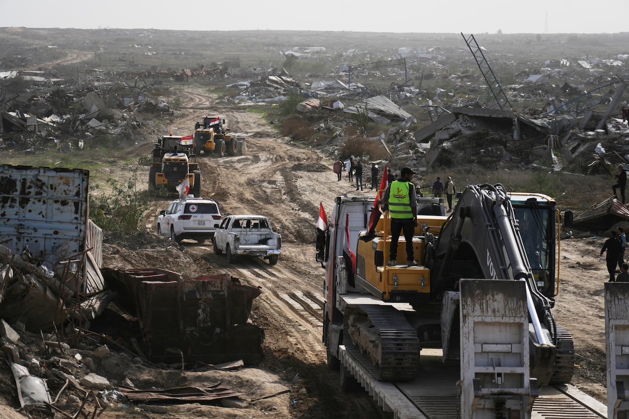 FILE - Hamas militants and Egyptian workers accompanied by members of the International Committee of the Red Cross (ICRC) head to Zeitoun neighborhood of Gaza City to search for the remains of deceased hostages, Dec. 8, 2025. (AP Photo/Jehad Alshrafi, File)