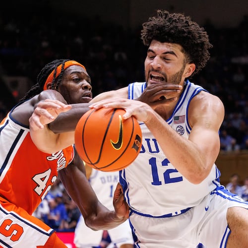 Duke's Cameron Boozer (12) handles the ball as Syracuse's William Kyle III, left, defends during the second half of an NCAA college basketball game in Durham, N.C., Monday, Feb. 16, 2026. (AP Photo/Ben McKeown)