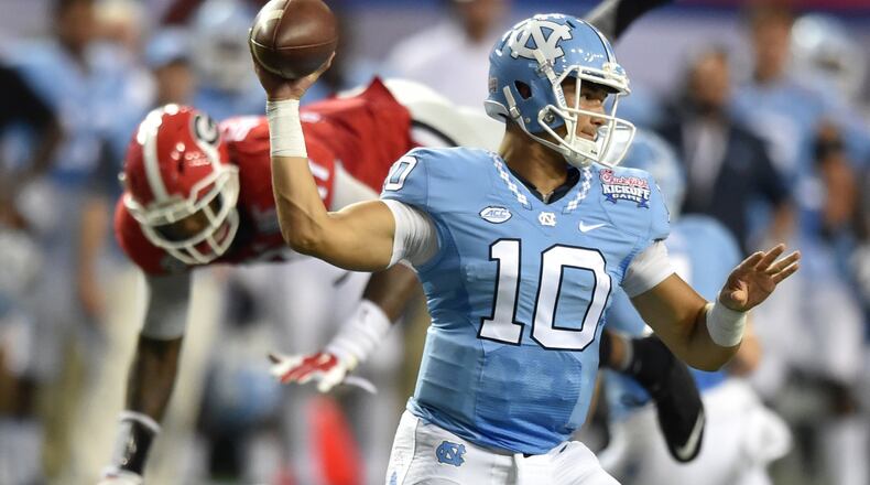 North Carolina Tar Heels quarterback Mitch Trubisky throws as Georgia Bulldogs linebacker Davin Bellamy leaps over a defender during the second half of the Chick-fil-A Kickoff game at the Georgia Dome on Saturday, September 3, 2016. BRANT SANDERLIN/BSANDERLIN@AJC.COM