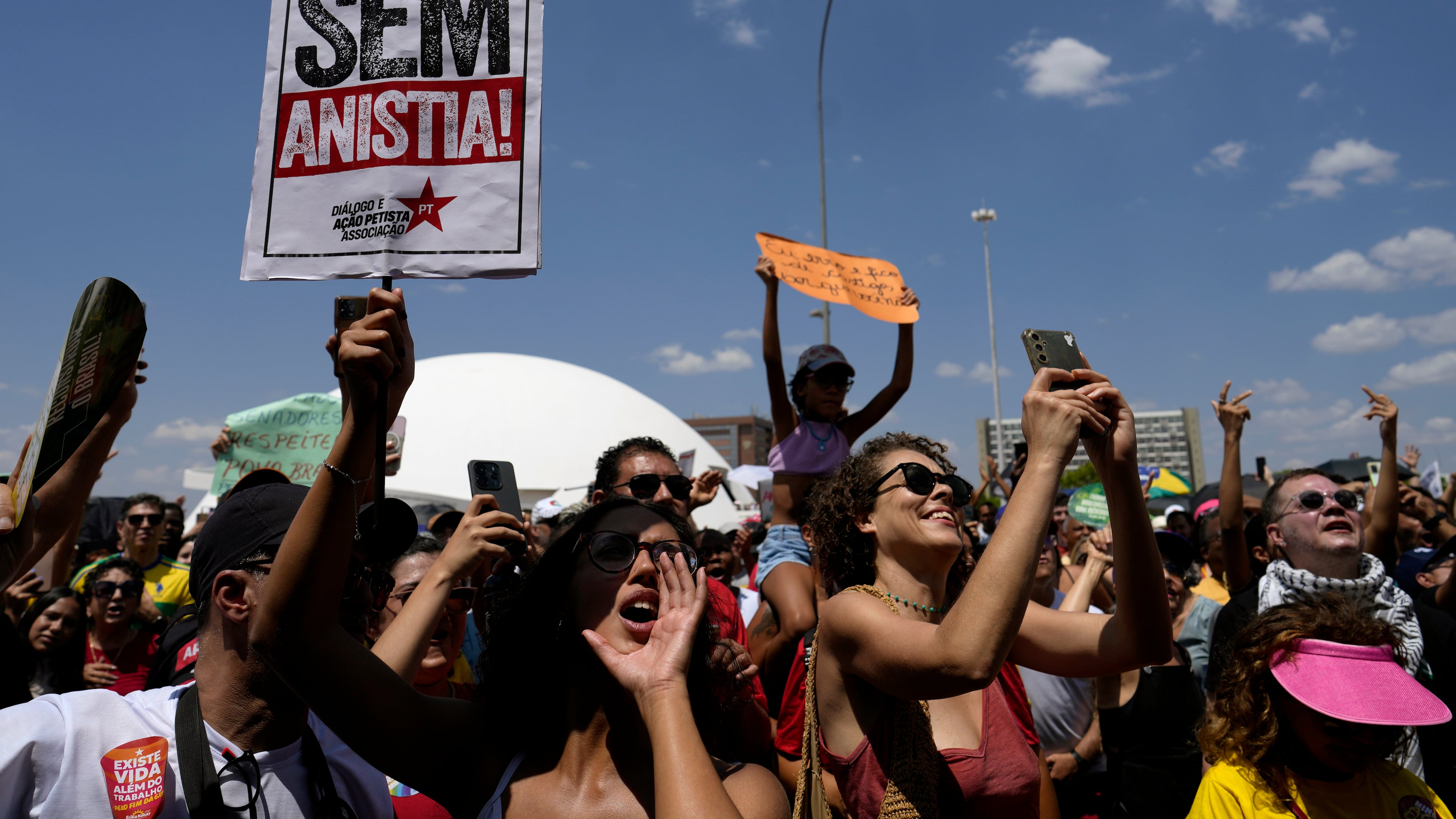 Activists chant "No amnesty" during a protest against an amnesty bill that could absolve former President Jair Bolsonaro and his allies convicted for a 2023 coup attempt, in Brasilia, Brazil, Sunday, Sept. 21, 2025. (AP Photo/Eraldo Peres)