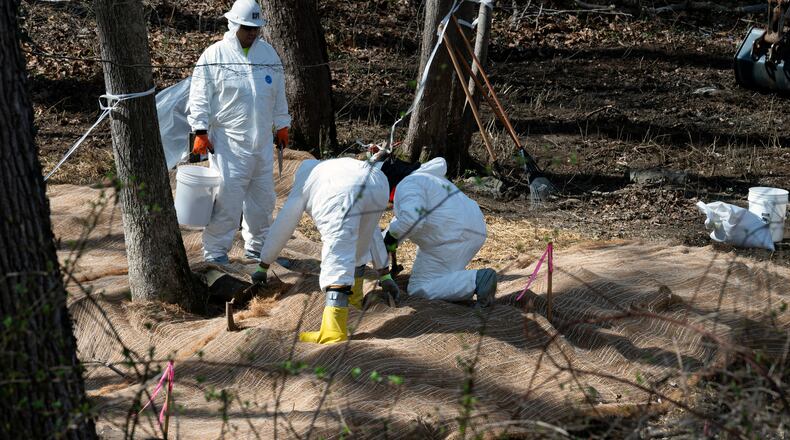 FILE - Workers prepare to take soil samples where raw sewage flowed near the Potomac River in Cabin John, Md., March 14, 2026. (AP Photo/Cliff Owen, File)