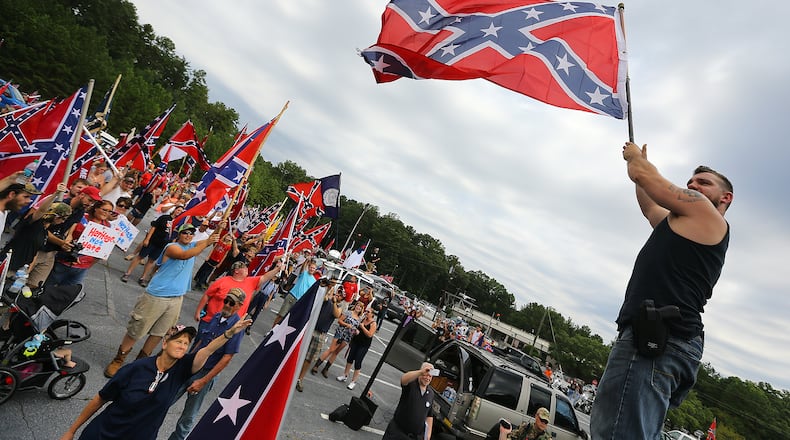 080215 STONE MOUNTAIN: Travis Conklin, Barnesville, waves a flag from the top of his truck durig a pro-Confederate flag rally at Stone Mountain Park on Saturday, August 1, 2015, in Stone Mountain. Curtis Compton / ccompton@ajc.com