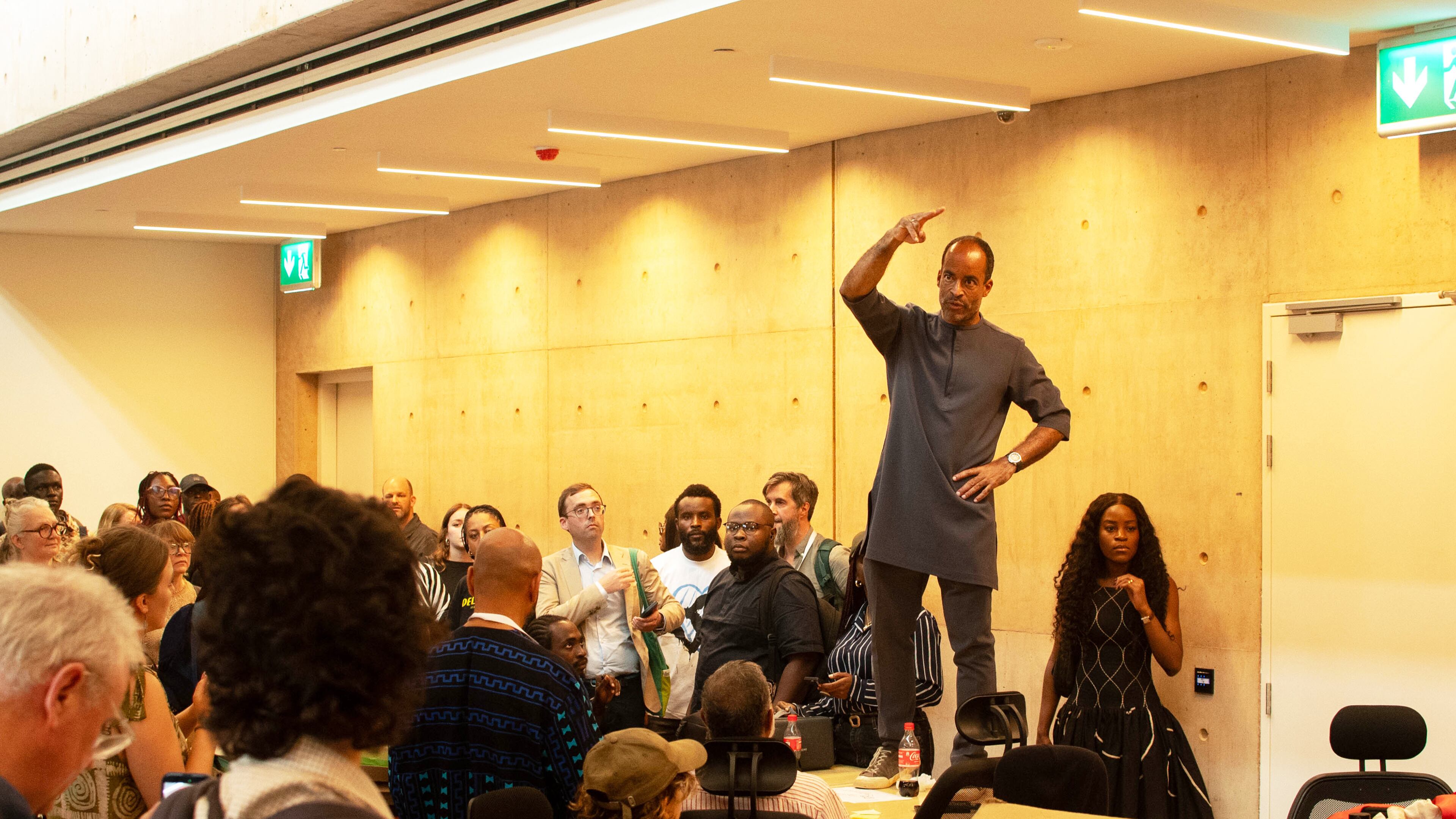 A man speaks to guests to calm down during the soft launch of the new, state backed, Museum of West African Arts, that was disrupted by protesters in Benin City, Nigeria, Sunday, Nov. 9, 2025. (AP Photo/Akpobasaha Oghenemaro Godspower )