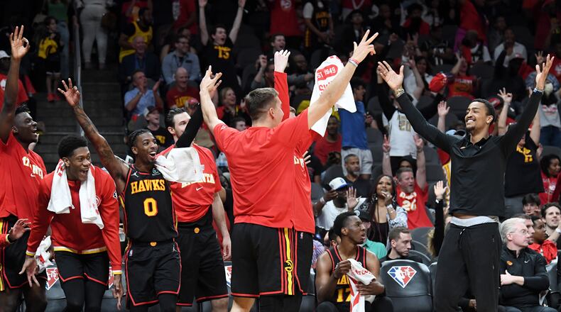Hawks players celebrate at the end of the game in the NBA play-in tournament Wednesday at State Farm Arena. Atlanta defeated Charlotte 132-103. (Hyosub Shin / Hyosub.Shin@ajc.com)