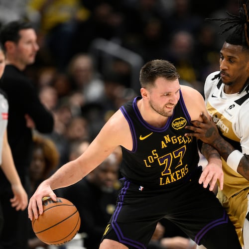Los Angeles Lakers guard Luka Doncic (77) dribbles against Washington Wizards guard Jamir Watkins, right, during the first half of an NBA basketball game, Friday, Jan. 30, 2026, in Washington. (AP Photo/Nick Wass)