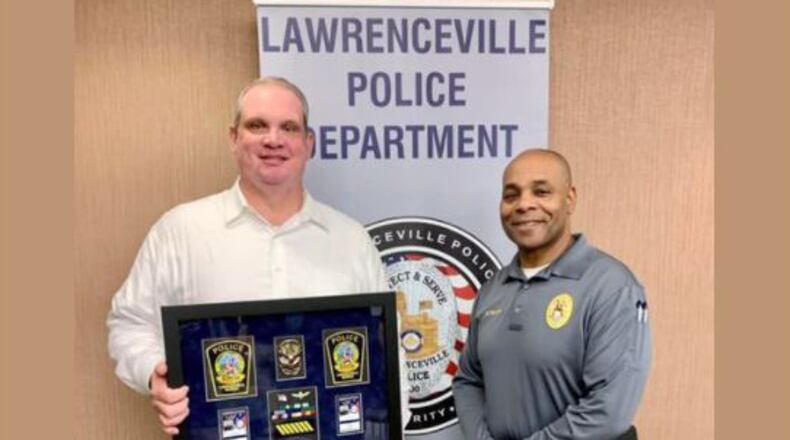 Lawrenceville Police Capt. Christopher Ryan Morgan, (left), is pictured here as the department celebrated his retirement in late December. He is standing with Maj. Myron Walker, the agency's assistant chief. (Lawrenceville PD Facebook page)
