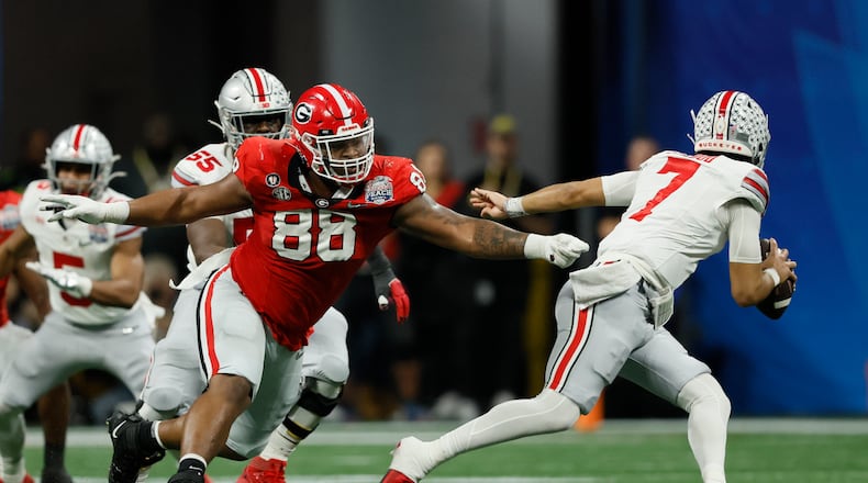 Ohio State quarterback C.J. Stroud (7) eludes the pressure from Georgia defensive lineman Jalen Carter (88) during the first half in the Peach Bowl Playoff Semifinal at Mercedes-Benz Stadium, Sat., Dec. 31, 2022, in Atlanta. Georgia won 42-41. (Jason Getz / Jason.Getz@ajc.com)