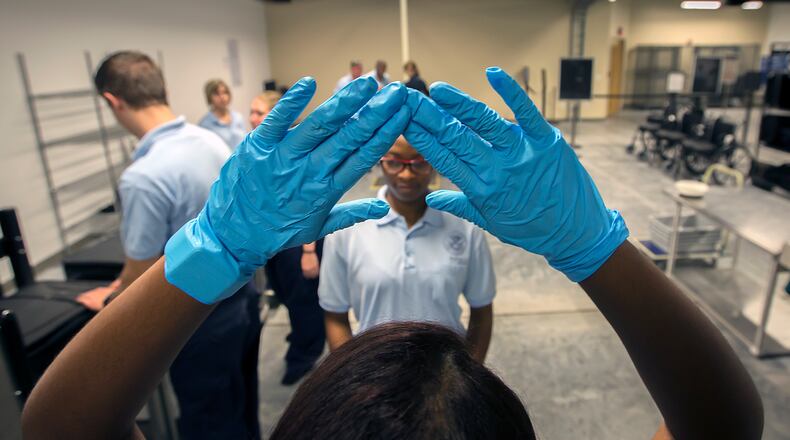 BRUNSWICK, GA - JULY 27, 2016: Transportation Security Administration Academy student Vivianette Calazan, left, of Puerto Rico trains with other student at a mock screening classroom at the new TSA Academy in Brunswick, Ga.