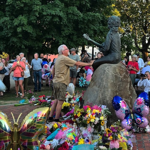 James A. Gambrell, a former chef at Dollywood, touches the Dolly Parton statue in downtown Sevierville, Tenn., on Tuesday, Aug. 25, 2026. (AP Photo/Dylan Lovan)