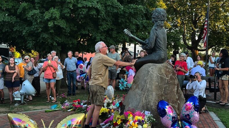 James A. Gambrell, a former chef at Dollywood, touches the Dolly Parton statue in downtown Sevierville, Tenn., on Tuesday, Aug. 25, 2026. (AP Photo/Dylan Lovan)