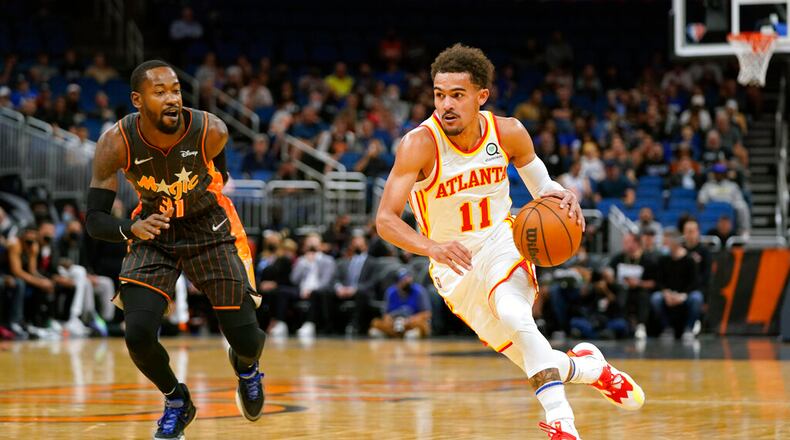 Atlanta Hawks guard Trae Young (11) drives around Orlando Magic guard Terrence Ross (31) during the first half of an NBA basketball game, Wednesday, Dec. 15, 2021, in Orlando, Fla. (AP Photo/John Raoux)