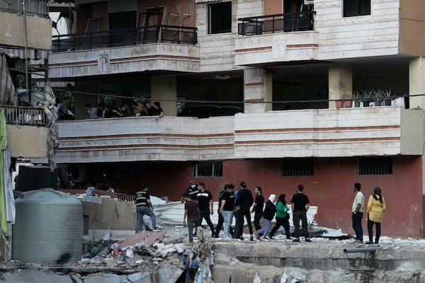 Residents inspect the area following an Israeli airstrike on Dahiyeh in the southern suburb of Beirut, Lebanon, Sunday, April 27, 2025. (AP Photo/Bilal Hussein)