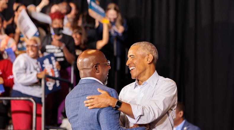 Former President Barack Obama, right, embraces U.S. Sen. Raphael Warnock during a metro Atlanta campaign event for Democrats in October. Obama will return to the area on Dec. 1 to give a boost to Warnock's campaign in the Dec. 6 runoff.  (Arvin Temkar / arvin.temkar@ajc.com)