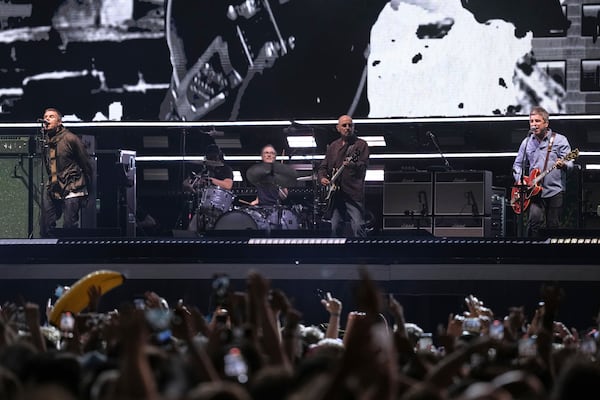 Liam Gallagher, left, and Noel Gallagher, right, from the band Oasis perform during their reunion concert on Friday, July 4, 2025, in Cardiff. (Photo by Scott A Garfitt/Invision/AP)