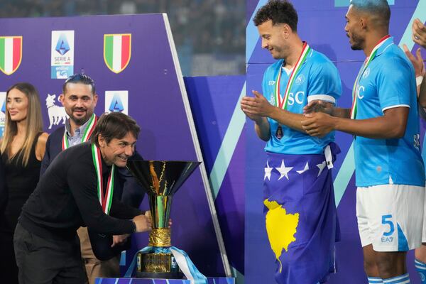 Napoli's head coach Antonio Conte celebrates with the trophy after winning the Italian league soccer title at the end of the Serie A soccer match between Napoli and Cagliari at the Diego Maradona stadium in Naples, Italy, Saturday, May 24, 2025. (AP Photo/Gregorio Borgia)
