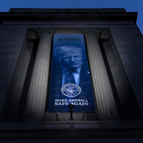FILE - A banner with a portrait of President Donald Trump is hung from the Department of Justice, March 7, 2026, in Washington. (AP Photo/Jose Luis Magana)