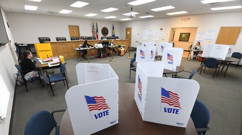 Stations to fill out ballots are shown vacant as poll wokers wait to assist during special election voting at city hall to fill an empty city council seat on Tuesday, March 24, 2020, in Dacula.