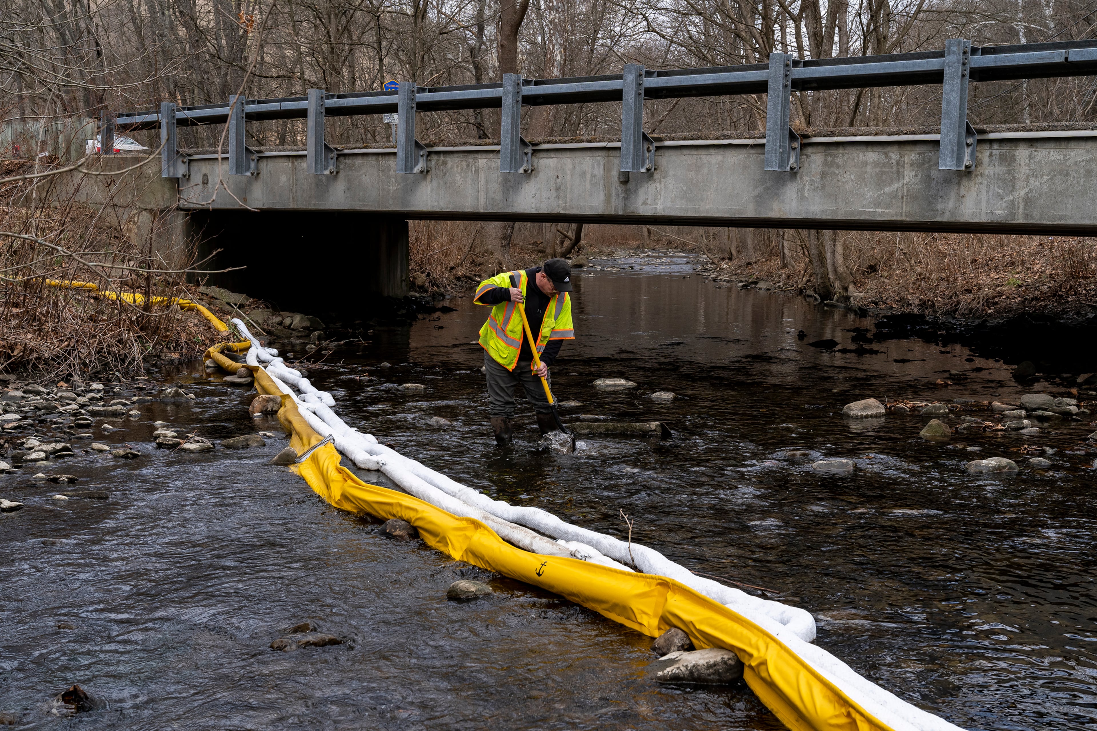 Ron Fodo, Ohio EPA Emergency Response, looks for signs of fish in Leslie Run creek to check for chemicals that might have settled at the bottom following the Norfolk Southern train derailment in Ohio. (Michael Swensen/Getty 2023)