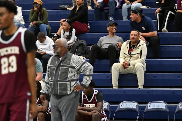 Donald Hartry (background right in tracksuit), brother of Tucker coach James Hartry (foreground in sweater), watches the Tigers take on Cambridge on Saturday, Feb. 28, 2026, in Milton. (Hyosub Shin/AJC)