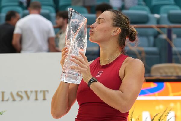 Aryna Sabalenka kisses the Butch Buchholz trophy after defeating Jessica Pegula during the women's singles final match at the Miami Open tennis tournament, Saturday, March 29, 2025, in Miami Gardens, Fla. (AP Photo/Marta Lavandier)