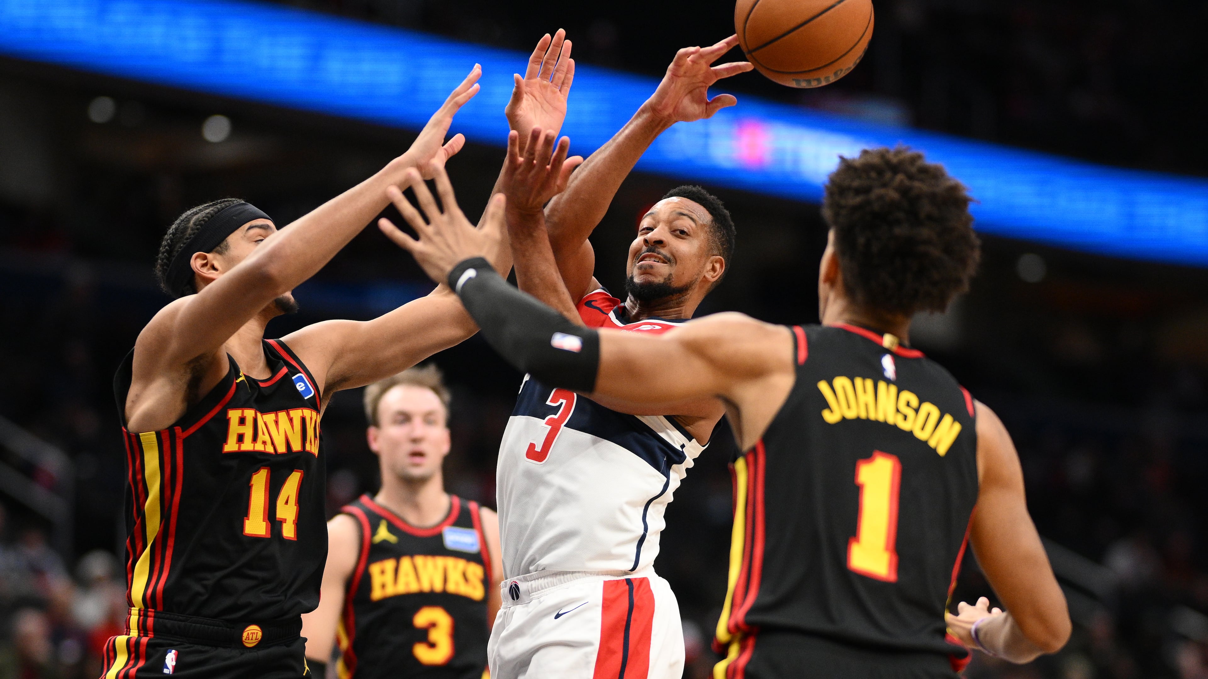 Washington Wizards guard CJ McCollum (3) passes the ball against Atlanta Hawks forward Asa Newell (14), forward Jalen Johnson (1) and guard Luke Kennard (3) during the first half of an NBA basketball game, Saturday, Dec. 6, 2025, in Washington. (AP Photo/Nick Wass)