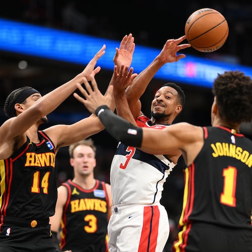Washington Wizards guard CJ McCollum (3) passes the ball against Atlanta Hawks forward Asa Newell (14), forward Jalen Johnson (1) and guard Luke Kennard (3) during the first half of an NBA basketball game, Saturday, Dec. 6, 2025, in Washington. (AP Photo/Nick Wass)