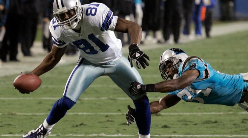 ARCHIVO - En esta foto de archivo del 22 de diciembre de 2007, Terrell Owens, de los Cowboys de Dallas, se escapa de Richard Marshall, de los Panthers de Carolina para lograr un touchdown (AP Foto/Chuck Burton, archivo)