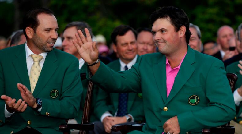 Former Masters champion Sergio Garcia, left, of Spain, speaks with Patrick Reed's after his win at the Masters golf tournament Sunday, April 8, 2018, in Augusta, Ga. (AP Photo/Chris Carlson)