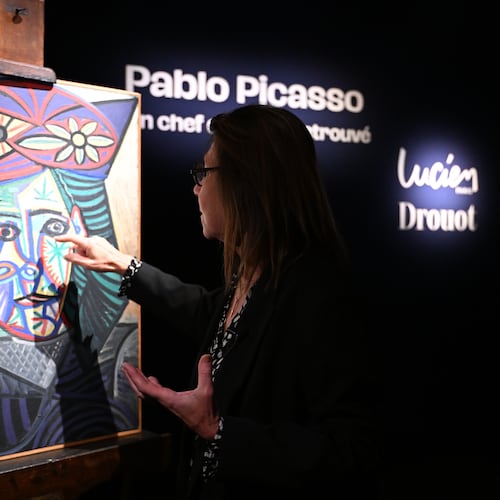 Art expert Agnes Sevestre-Barbe points to a rediscovered Picasso painting "Bust of a Woman in a Flowery Hat", Wednesday, Oct. 22, 2025 in Paris. The portrait painted in 1943 will be sold at auction Friday in Paris, was bought in 1944 and shows his partner Dora Maar. (AP Photo/Emma Da Silva)