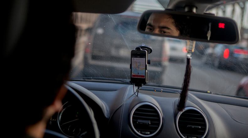 FILE-- An Uber driver drives on the Brooklyn Bridge in New York, Jan. 30, 2015. Uber has announced a host of software improvements to its app to address driver demands. Among the changes, drivers can now more easily pause ride requests, making it easier for them to take bathroom breaks and fill their gas tanks. They can also be paid instantly for each ride they complete, rather than weekly, and see on the app?s dashboard how much they have earned. (Sam Hodgson/The New York Times)