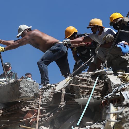 Residents and rescue workers search through the rubble after an earthquake struck Cali, Colombia, Monday, Aug. 10, 2026. (AP Photo/Santiago Saldarriaga)