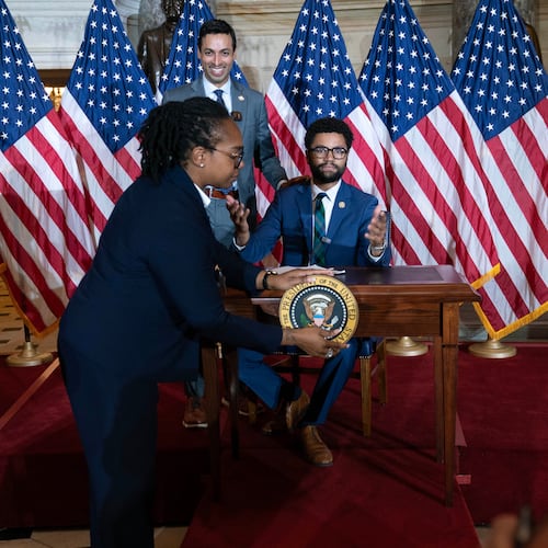 Rep. Suhas Subramanyam, D-Va., left, and Rep. Maxwell Frost D-Fla., speaks at a desk prepared for President Donald Trump as an official removes the presidential seal, after President Trump canceled the signing the bipartisan Housing Bill on the Capitol Wednesday, June 24, 2026, in Washington. (AP Photo/Jose Luis Magana)