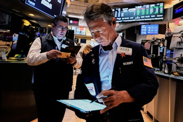 Traders Michael Capolino, left, and Robert Charmak work on the floor of the New York Stock Exchange, Monday, May 12, 2025. (AP Photo/Richard Drew)