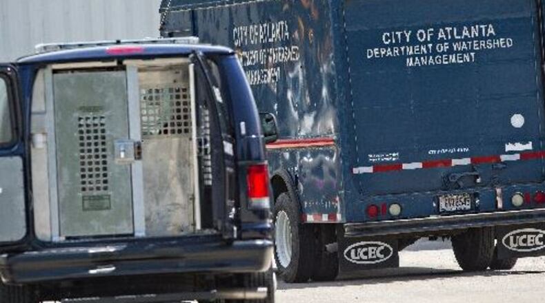An Atlanta Police prisoner transport van waits in the parking lot of the Atlanta Department of Watershed Management in May 2015 following arrests of employees. AJC File Photo