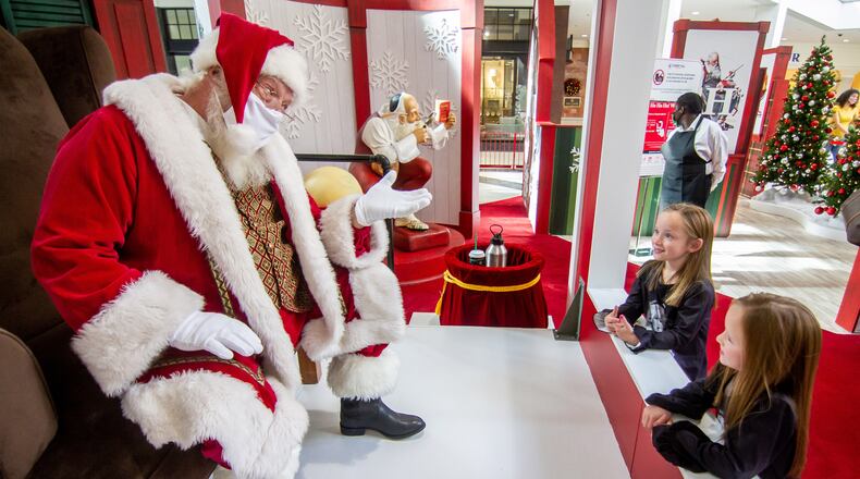 Brooklynn McCarty, 8, (R) and her twin sister Madison, 8, talk with Santa Clause at the Perimeter Mall Sunday, November 22, 2020 STEVE SCHAEFER / SPECIAL TO THE AJC