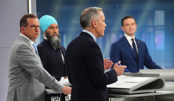 Bloc Quebecois Leader Yves-Francois Blanchet, New Democratic Party Leader Jagmeet Singh and Conservative Leader Pierre Poilievre listen to Liberal leader Mark Carney speak during the French-language federal leaders' debate, in Montreal, Wednesday, April 16, 2025. (Sean Kilpatrick/The Canadian Press via AP)