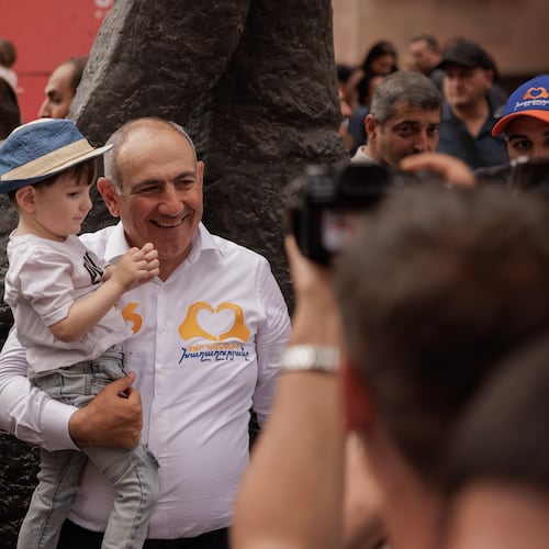 Armenian Prime Minister Nikol Pashinyan holds a child as he walks on Northern Avenue in Yerevan, Armenia, Monday, June 1, 2026, during public celebrations marking International Children's Day. (AP Photo/Anthony Pizzoferrato)