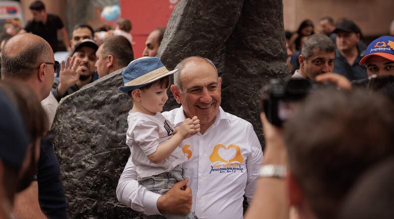 Armenian Prime Minister Nikol Pashinyan holds a child as he walks on Northern Avenue in Yerevan, Armenia, Monday, June 1, 2026, during public celebrations marking International Children's Day. (AP Photo/Anthony Pizzoferrato)